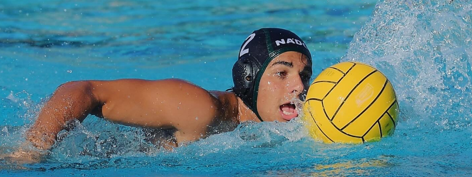 High school water polo player advancing the ball