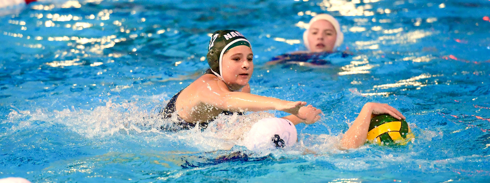 Junior water polo player driving with the ball
